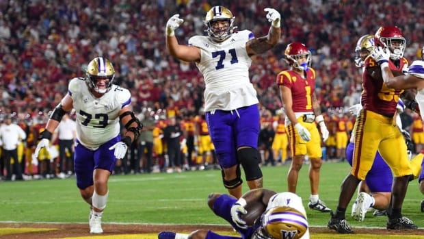 Roger Rosengarten (73) and Nate Kalepo (71) follow UW running back Dillon Johnson into the end zone.